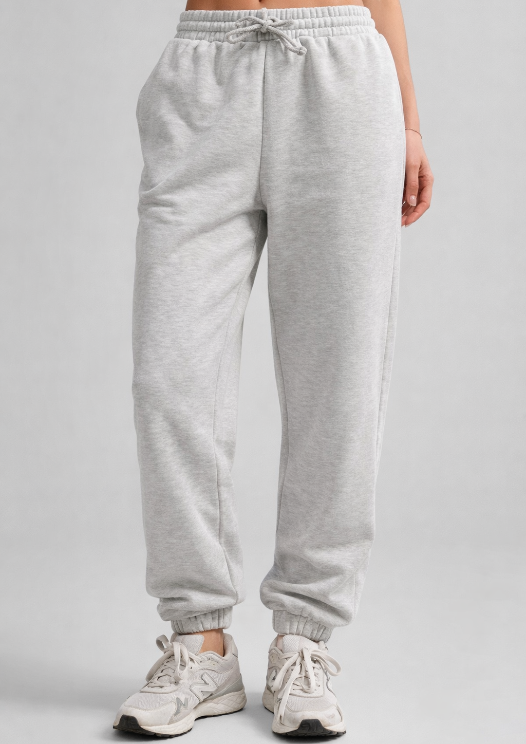 Gray sweatpants worn by a person on a plain background