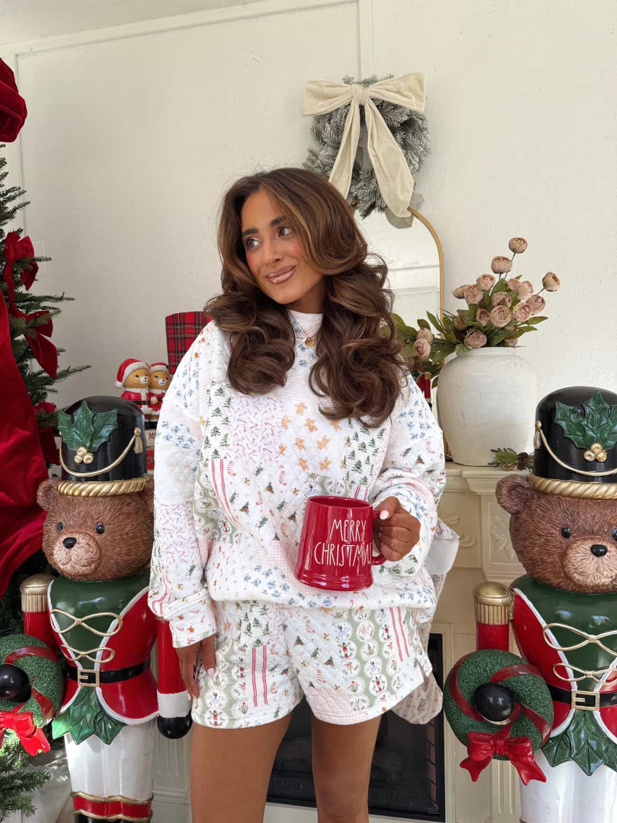 Woman holding a mug with Christmas decorations in the background