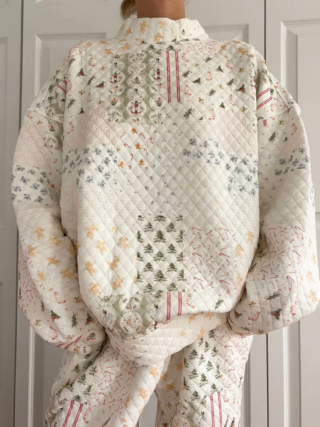 Person wearing a quilted floral patterned jacket against a neutral background